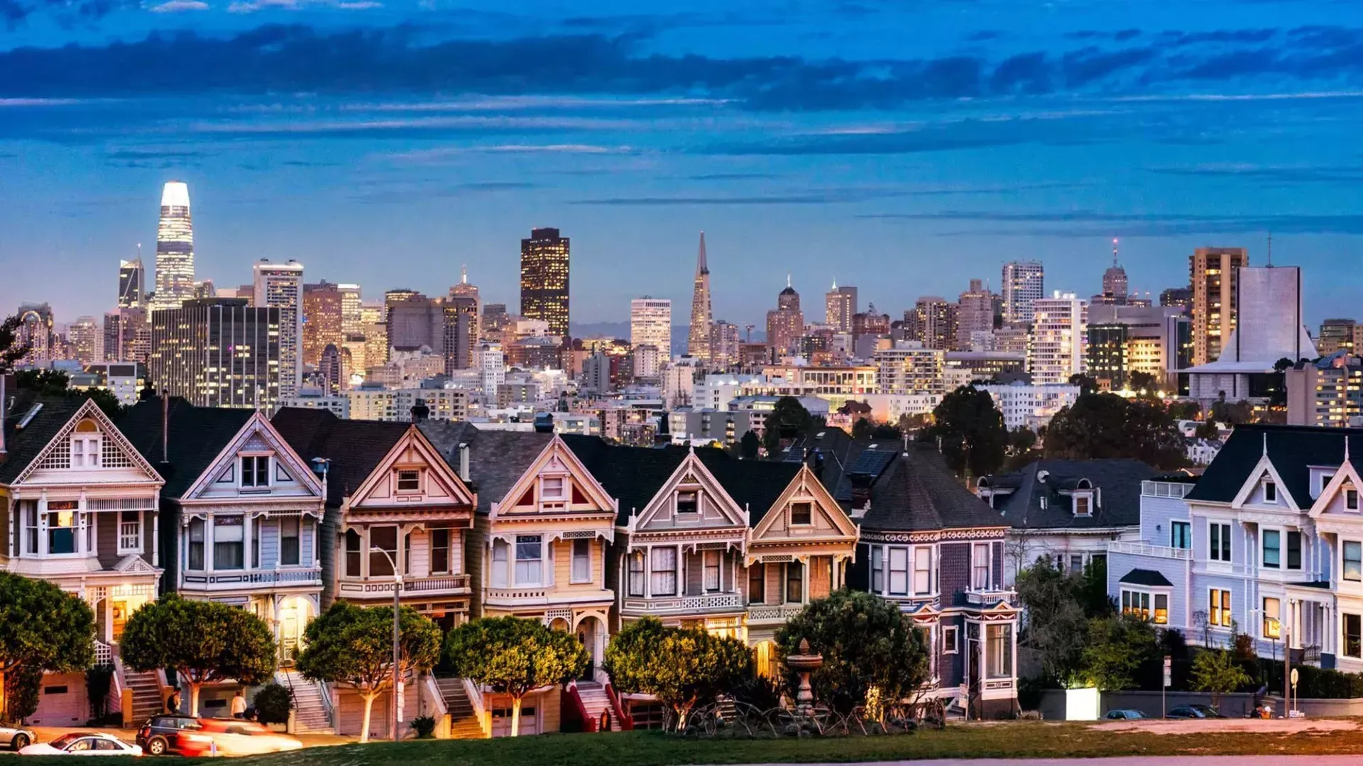 Les célèbres 浓的女人 d'Alamo Square sont représentées devant l'horizon de 贝博体彩app au crépuscule.